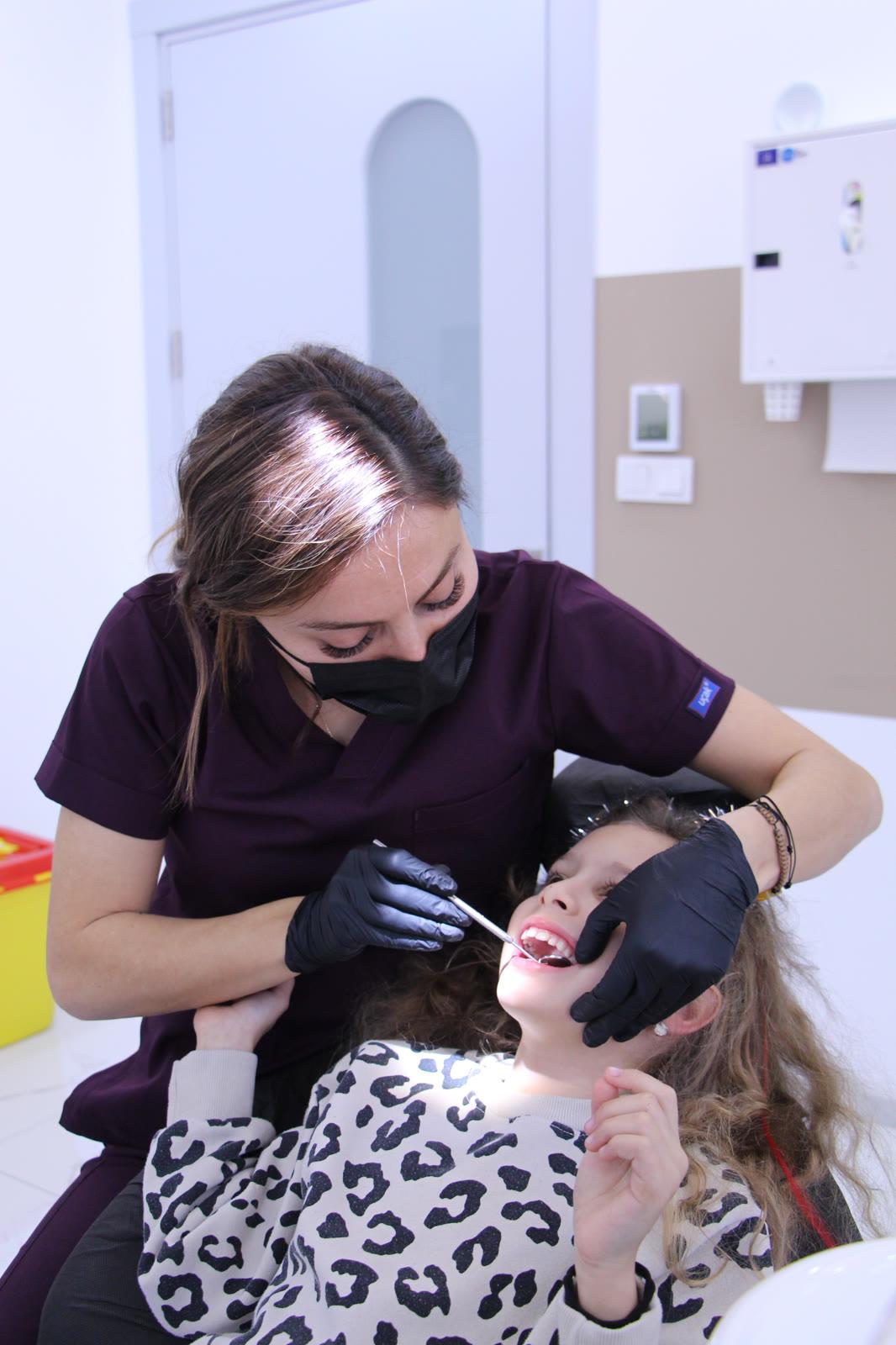 Pedodonti Diş Hekimi Narmin Ismayilova, klinikte bir kız çocuğunun diş muayenesini yapıyor