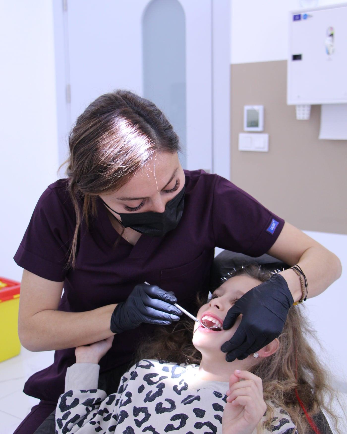 Uzm. Dt. Narmin Ismayilova, Fethiye'deki kliniğinde bir çocuk hastanın diş muayenesini yapıyor